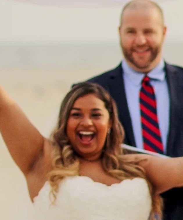 A bride celebrating next to Jim on the beach