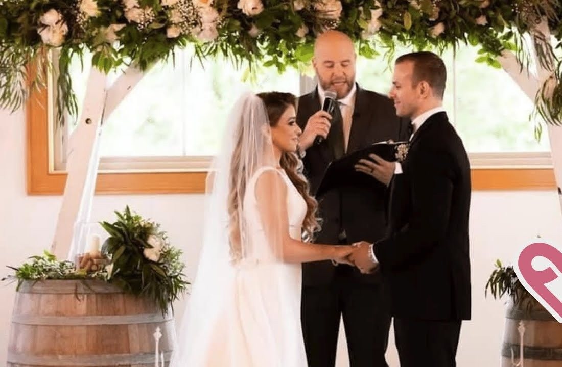 Jim officiating under a floral arch